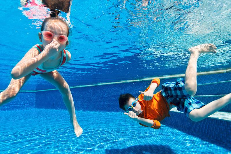 Children holding their breath underwater at a swimming pool